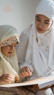 Parents sitting with their young child at a table, helping with homework or an online lesson