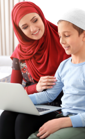 Parents sitting beside their child at a desk, helping with an online class on a laptop, showing encouragement and support.