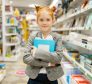 A young schoolgirl wearing a backpack, joyfully browsing colorful notebooks and school supplies in a stationery store